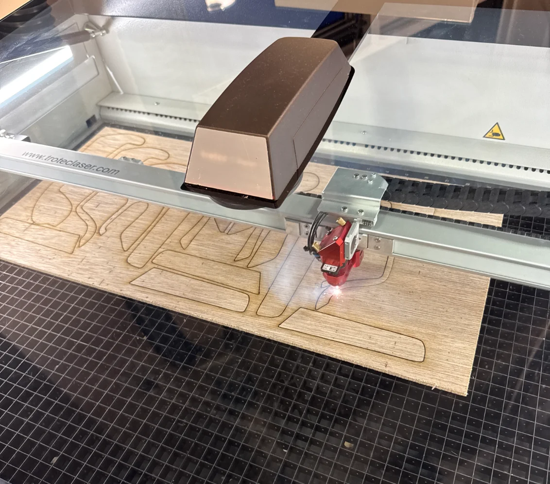 Plywood stand parts being cut on a CO2 laser cutter