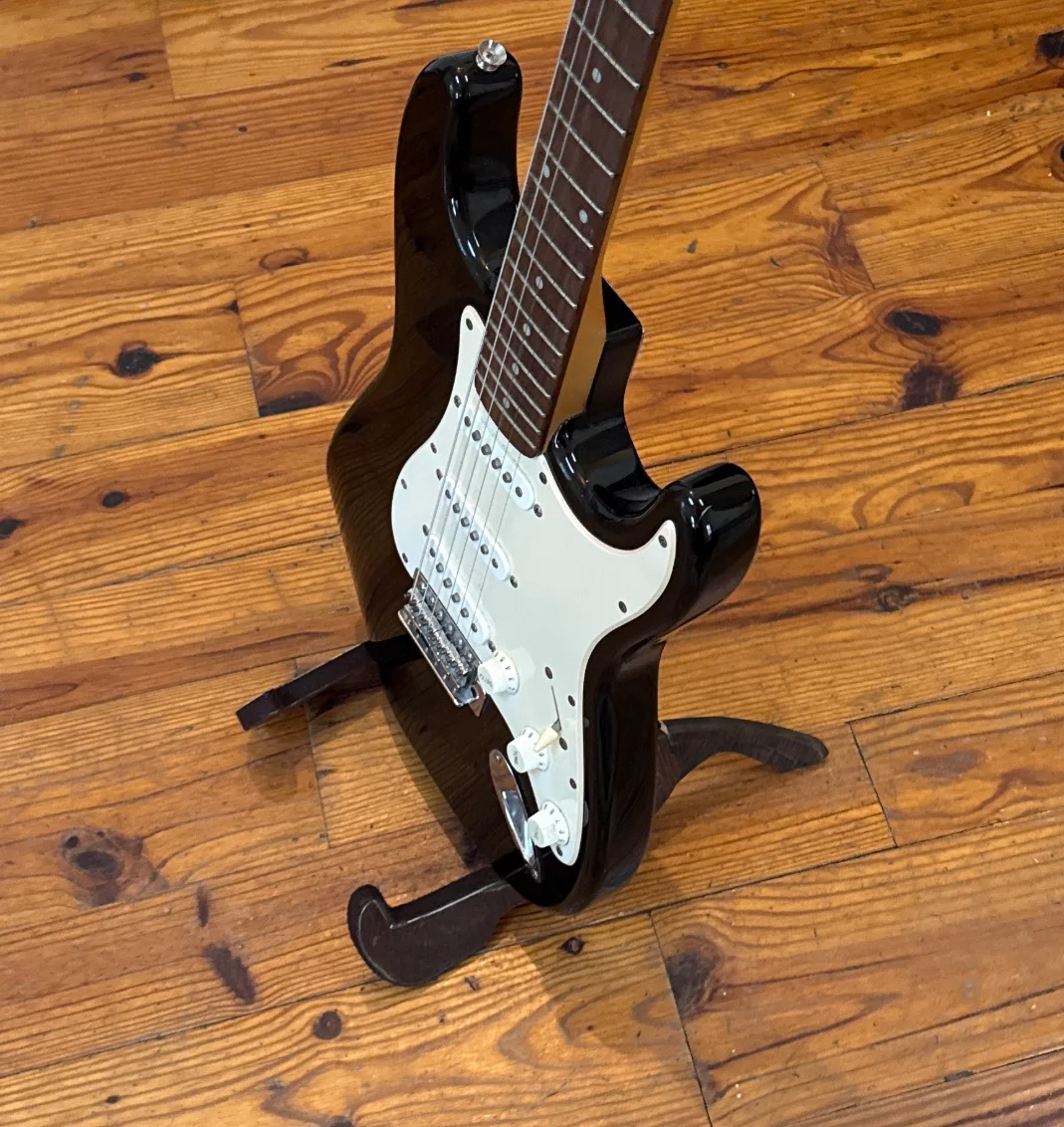 An electric guitar held in the same stand