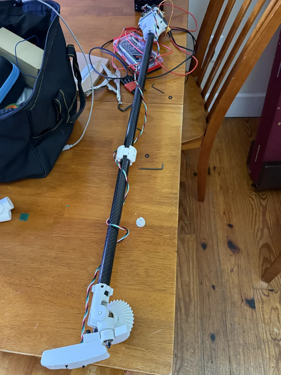 The assembled CZERVIK MK 0 on a workbench: grip-end electronics, the full carbon-fiber shaft with a printed clamp collar, and the geared head